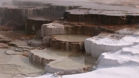 A-Colorful-Closeup-Look-At-A-Hot-Springs-Limestone-Terrace-With-Steam-Snow-And-Thermal-Pool
