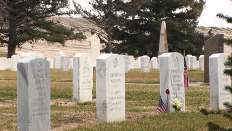 An-American-Flag-And-Flowers-Decorate-One-Of-So-Many-Headstones-At-Arlington-National-Cemetery