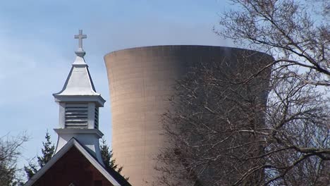 Camera-Focuses-On-A-Church-Steeple-And-A-Nuclear-Power-Plant-In-Close-Proximity