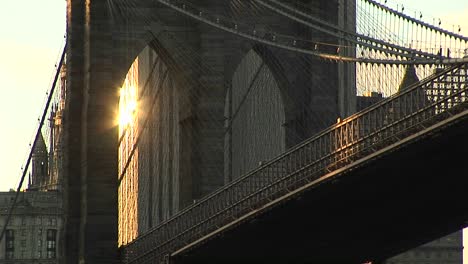 Die-Gothicarches-Der-Brooklyn-Bridge-Fangen-Nur-Das-Reflektierte-Licht-Von-Einem-Gebäude-In-Der-Ferne-Ein