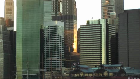 The-Camera-Pans-Up-From-Shore-Side-South-Street-Seaport-To-The-Very-Tops-Of-The-Surrounding-Skyscrapers-Including-The-Empire-State-Building-At-Goldenhour