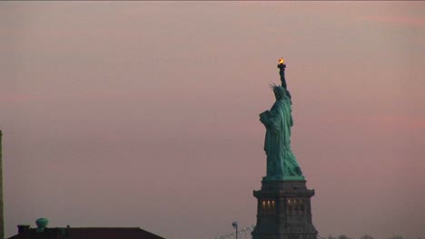 A-Striking-View-Of-The-Statue-Of-Liberty-Against-A-Pale-Pink-Sky