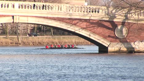 Longshot-Of-The-Harvard-University-Rowing-Team-Passing-Under-A-Bridge-Over-The-Charles-Rives-Near-Cambridge-Massachusetts