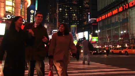Plano-Medio-De-Gente-Caminando-Por-Times-Square-De-Noche