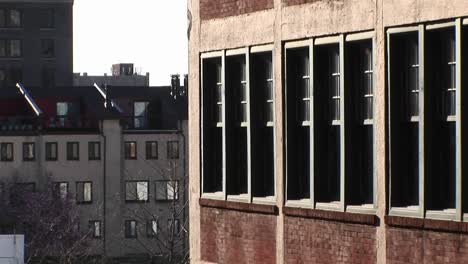 Die-Kamera-Zoomt-Auf-Ein-Altes-Schulgebäude,-Das-Sich-Neben-Moderneren-Stadthäusern-Befindet