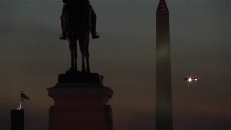 A-Statue-Of-Ulysses-S-Grant-Is-In-Silhouette-In-The-Foreground-Of-The-Washington-Monument-On-A-Cloudy-Night