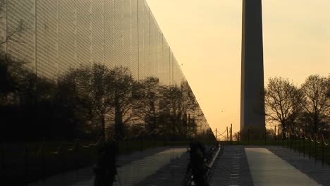 Mit-Goldener-Himmelskulisse-Ist-Das-Washington-Monument-In-Silhouette-Neben-Der-Vietnam-Memorial-Wall-Zu-Sehen