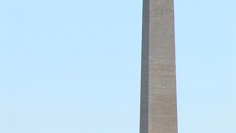 Das-Washington-Monument-Wird-An-Der-Basis-Von-Blühenden-Kirschbäumen-Flankiert-Und-Als-Kameraschwenk-Oben-Von-Ihnen-Eingerahmt