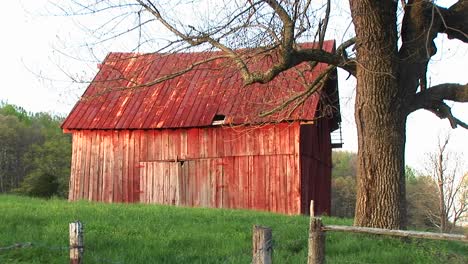 Faded-Red-Roof-And-Siding-Of-An-Old-Barn-Reflects-The-Passing-Of-The-Family-Farm-And-An-Entire-Era