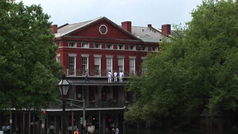 A-Mediumshot-Of-Repairmen-Standing-On-The-Balcony-Of-An-Old-Brick-Building-Doing-Repairs
