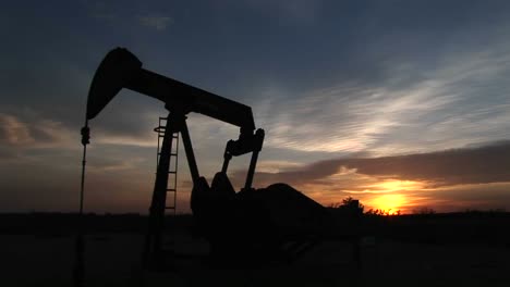 Mittlere-Aufnahme-Einer-Silhouettierten-Ölpumpe,-Die-Sich-In-Der-Wüste-Von-New-Mexico-Dreht-Und-Petroleum-Pumpt