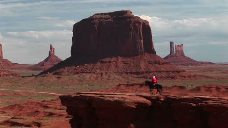 Lange-Aufnahme-Eines-Cowboys,-Der-Auf-Seinem-Pferd-Reitet,-Um-Im-Monument-Valley-Arizona-Zu-übersehen?