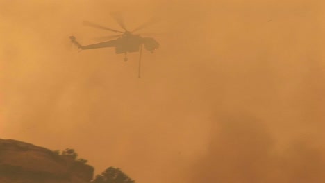 Following-Shot-Of-A-Helicopter-Dropping-Chemicals-On-A-Wildfire-In-California