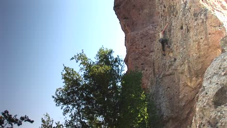 Longshot-Of-A-Rock-Climber-Scaling-Up-A-Cliff-Face