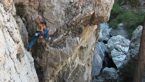 Longshot-Of-A-Rock-Climber-Rearranging-Her-Carabineers-To-Climb-A-Cliff-Wall