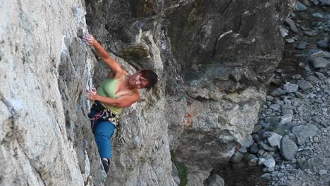 Bird'Seye-Shot-Of-A-Rock-Climber-Struggling-To-Pull-Herself-Up-A-Cliff-Wall