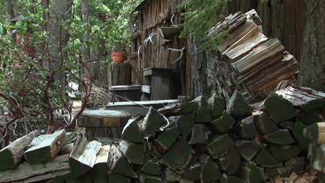 Medium-Shot-Of-Rural-Cabin-With-Wood-Pile-In-The-Sierra-Nevada-Mountains