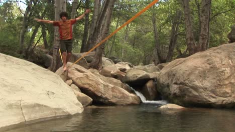 Jibup-Of-A-Young-Man-Slacklining-Across-A-Placid-Swimming-Hole