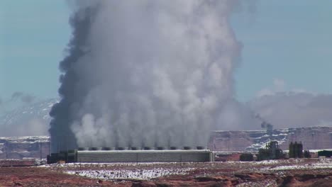 Mittlere-Aufnahme-Einer-Fabrik-In-Der-Wüste-Von-Arizona,-Die-Rauchwolken-Ausstößt