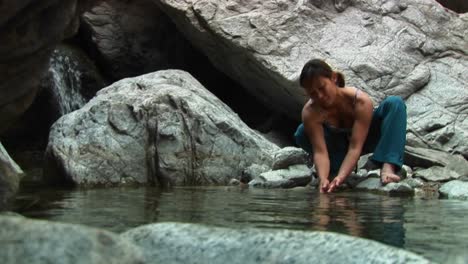 Medium-Shot-Of-A-Woman-Rockclimber-Washing-Her-Hands-In-A-Montaña-Pool