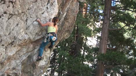 Mediumshot-Of-A-Rock-Climber-Making-Her-Way-Up-A-Sheer-Granite-Cliff-Face