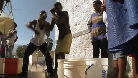 Menschen-Bekommen-Wasser-Aus-Einem-Brunnen-Nach-Einem-Massiven-Erdbeben-In-Haiti-1