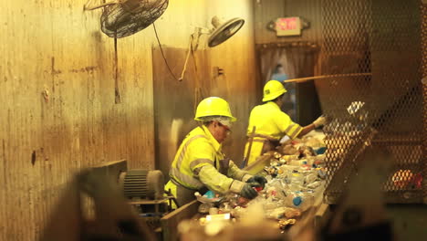 Workers-in-a-recycling-center-sorting-trash-on-conveyor-belts