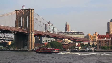 Eine-Fähre-Fährt-Unter-Der-Brooklyn-Bridge-In-New-York-Durch