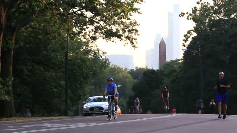 Joggers-and-bicyclists-pass-along-a-path-in-Central-Park-in-New-York-City