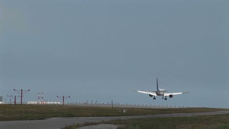 Wide-shot-of--jet-airplane-lands-on-an-airport-runway