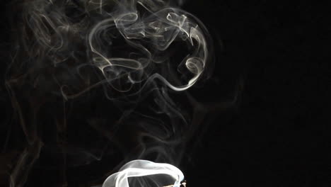Closeup-of-incense-smoke-rising-against-a-black-background-2