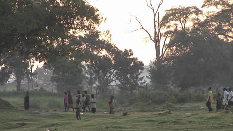 Panleft-shot-of-villagers-walking-along-a-path-in-Uganda-Africa