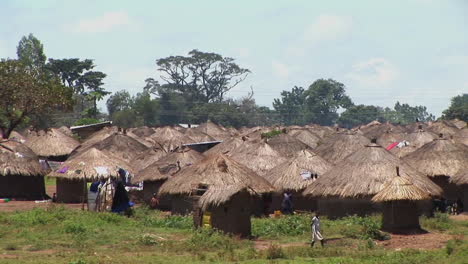 Folgeaufnahme-Eines-Jungen-Mädchens,-Das-Zu-Einem-Kleinen-Dorf-Oder-Flüchtlingslager-In-Uganda-Afrika-Geht-Walking