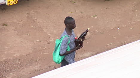 Un-Hombre-Lleva-Botellas-De-Cerveza-A-Través-Del-Tráfico-En-Kampala,-Uganda