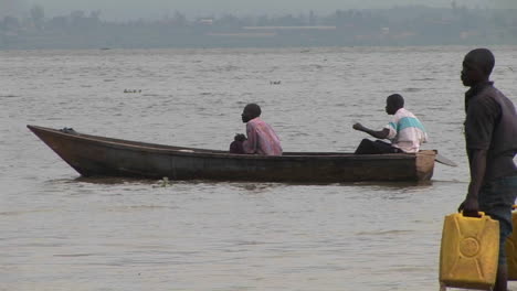 Mediumshot-of-a-man-rowing-a-johnboat-amidst-a-group-of-other-fishers-on-Lake-Victoria-Uganda