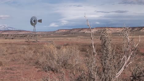 Long-shot-of-an-old-windmill-standing-out-in-a-desert-plain